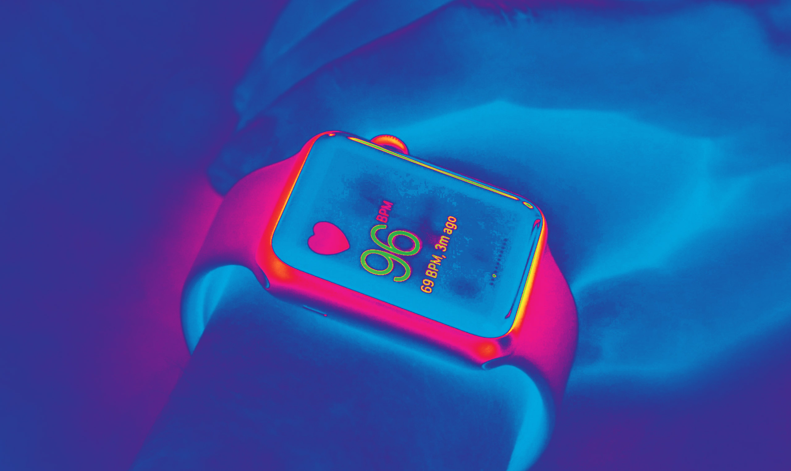 A person is holding an apple watch in front of a blue light.