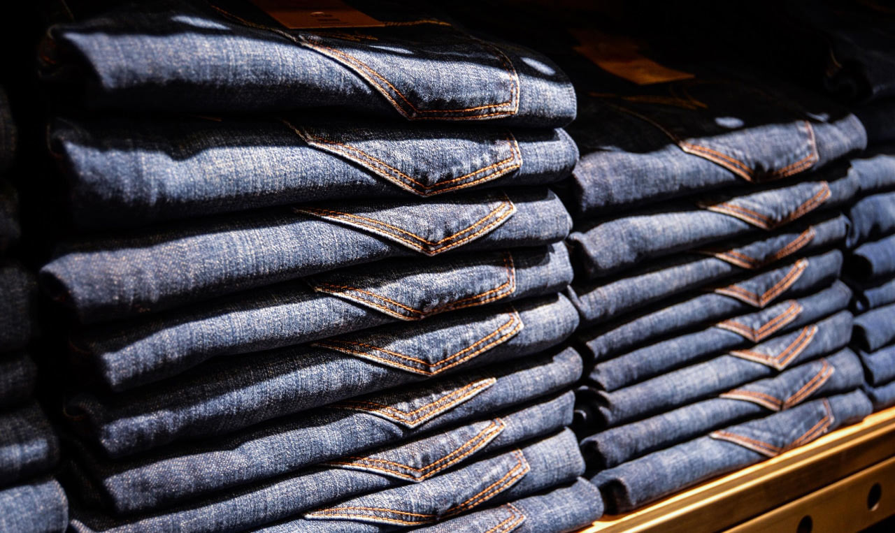 A stack of Levi's jeans on a shelf in a store.