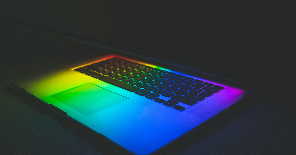 A laptop with a rainbow colored light on it.