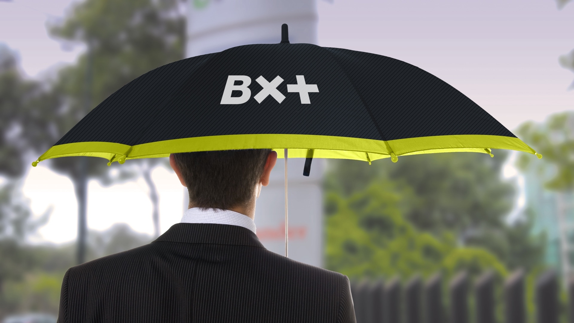 a man standing with a black umbrella with the BX+ logo.