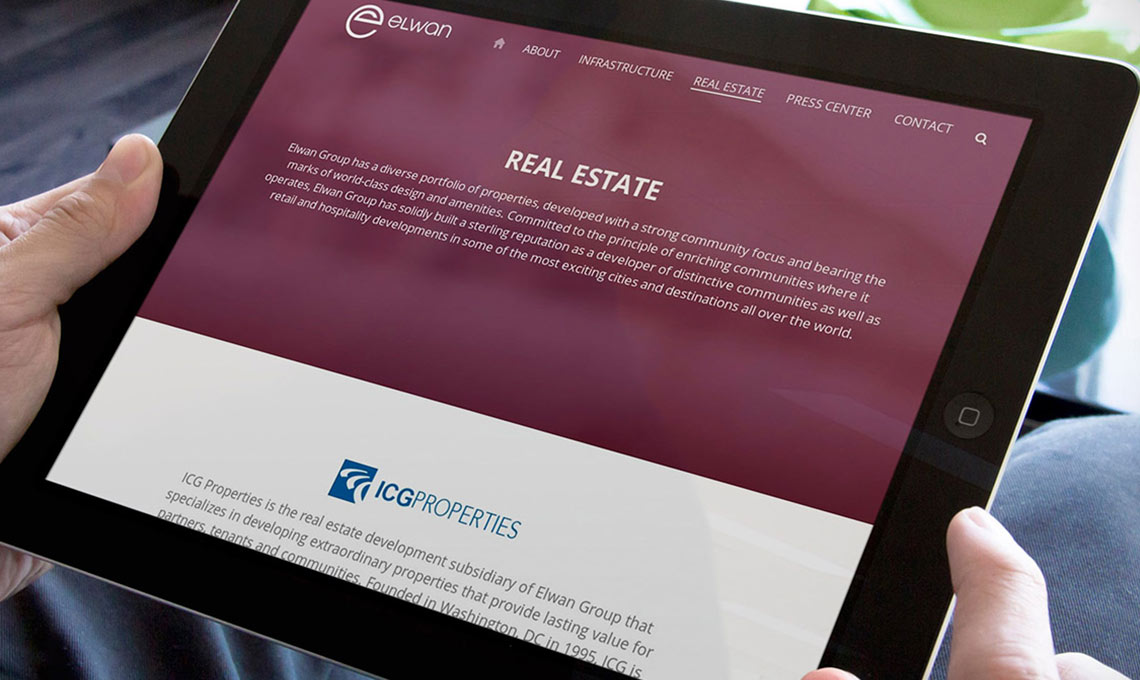 A man with a tablet in his hands with the website designed for Elwan Group