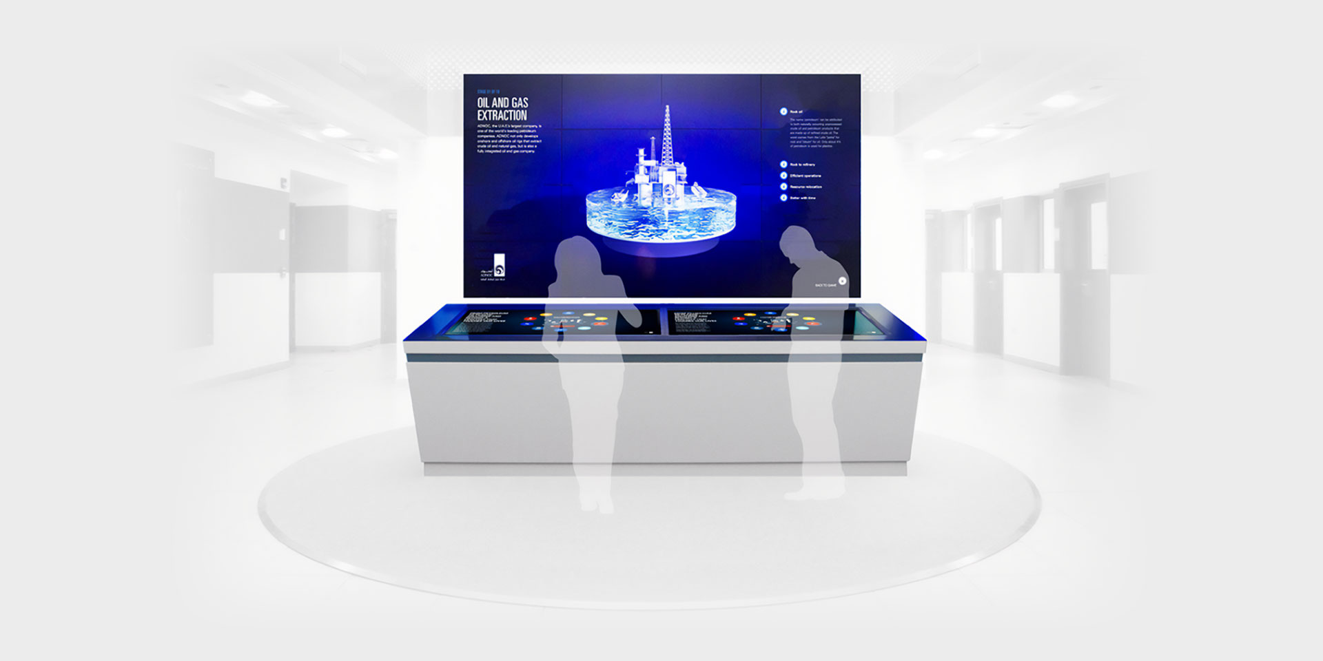 a digital and interactive display in a white showroom with people standing around it