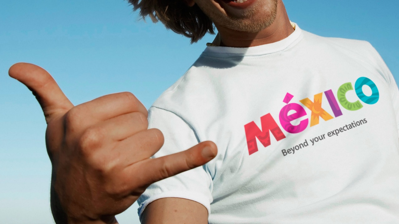 A man giving the thumbs up in a mexican t - shirt.