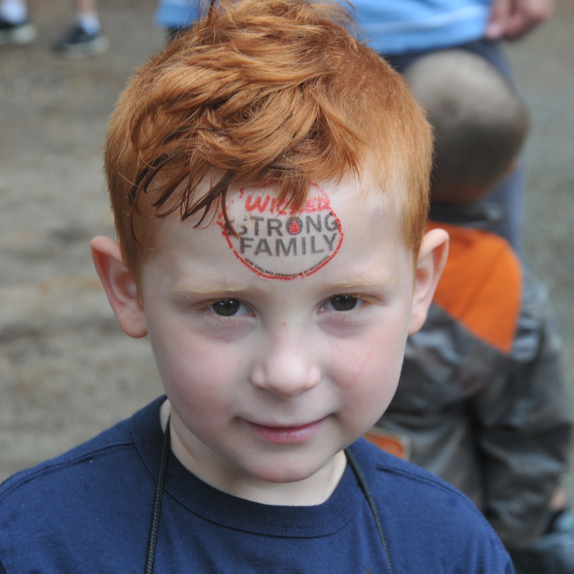 a young boy with a logo of NEHA on his forehead that says 