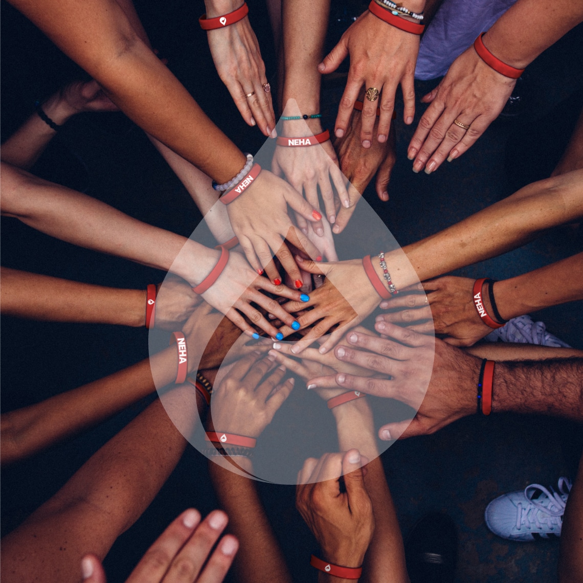 a group of people with their hands in a circle and the Neha symbol as a watermark
