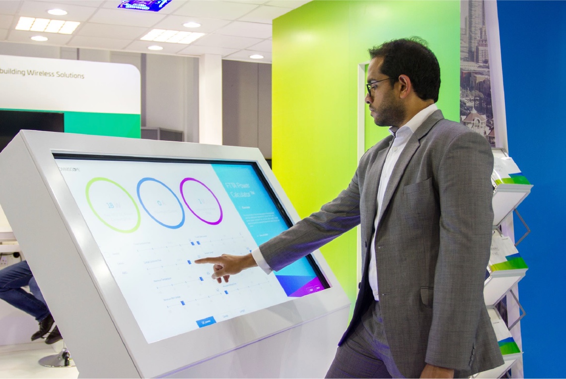 a person pointing at a touch screen showing the presentation developed for CommScope