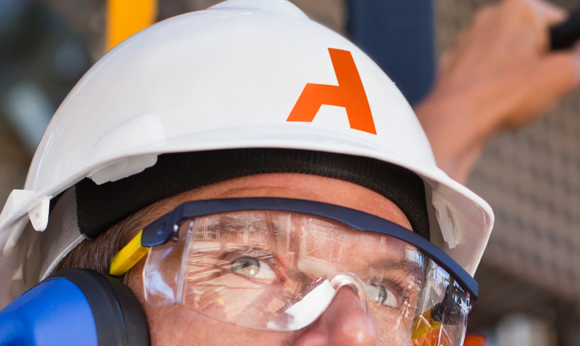A man representing brand identity, wearing a hard hat and safety goggles.