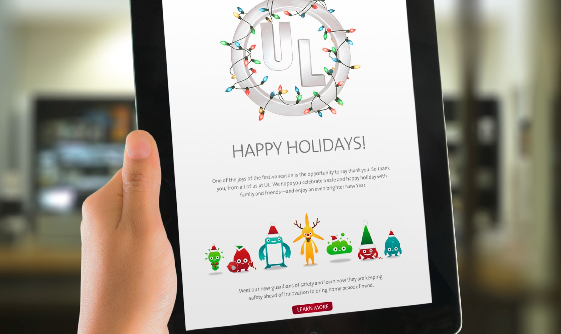 A person holding an ipad with a happy holidays screen.