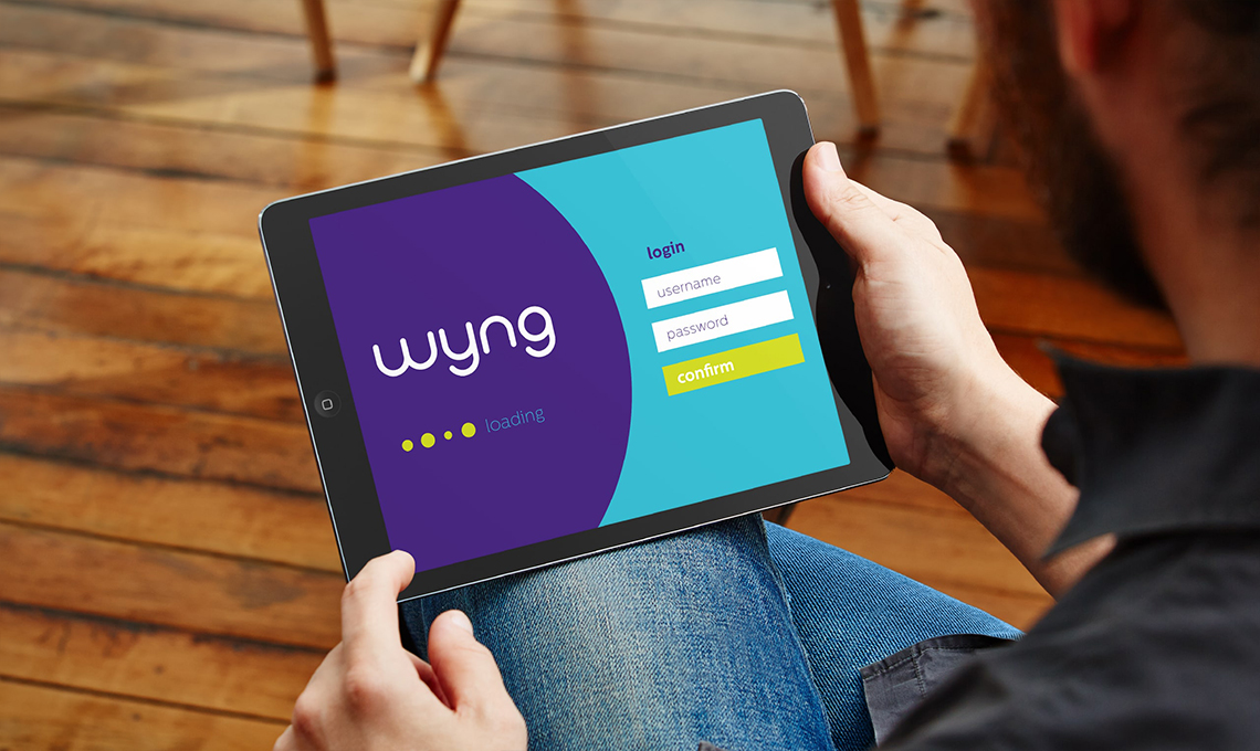 A man holding an ipad with the word gyw on it.