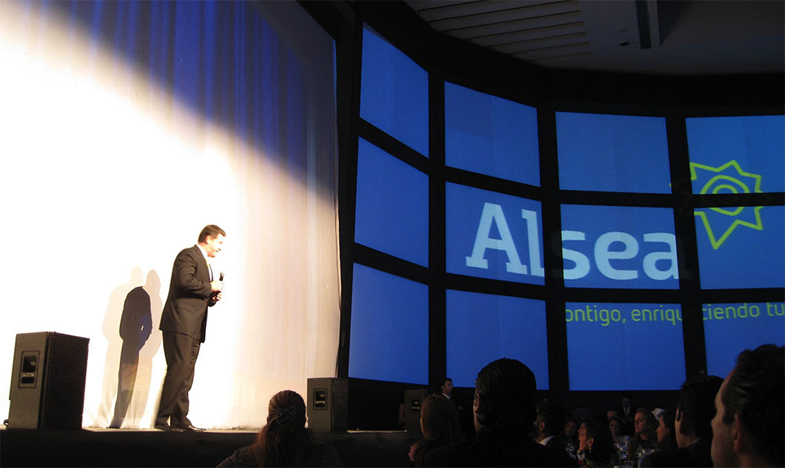 A man presenting on a stage as part of brand repositioning efforts.