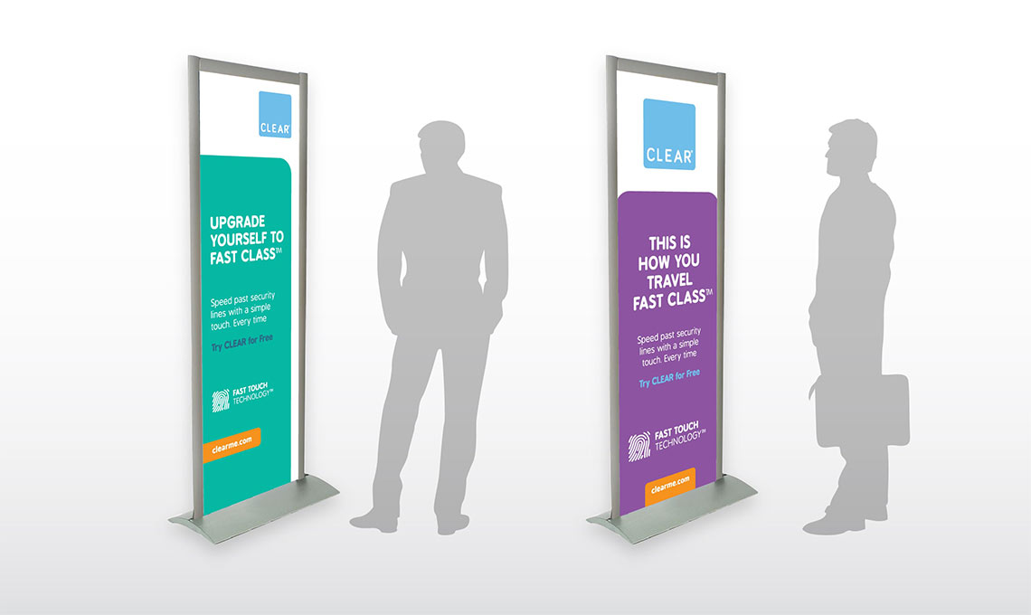 A group of people standing next to a roll up banner promoting brand awareness.