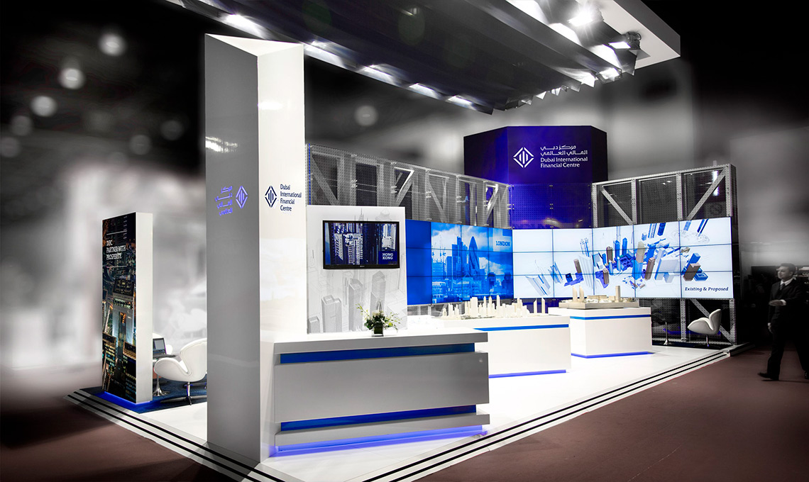 A trade show booth with blue lighting and white walls.