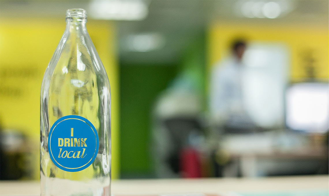 A bottle of water sits on a table in an office promoting local hydration.