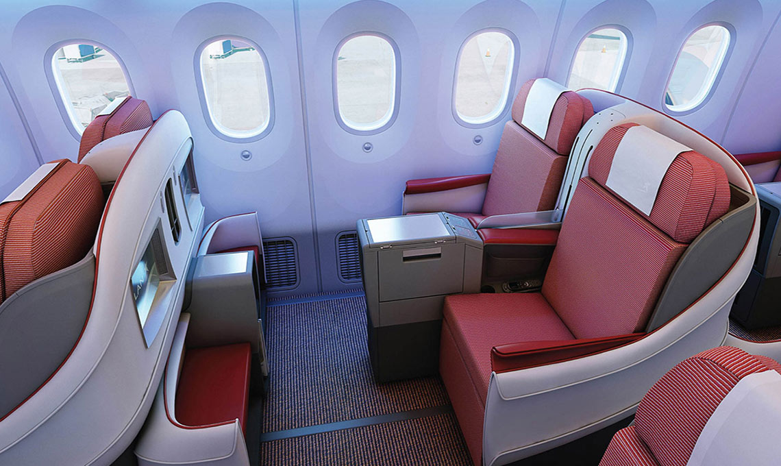 The interior of an airplane with red and white seats.