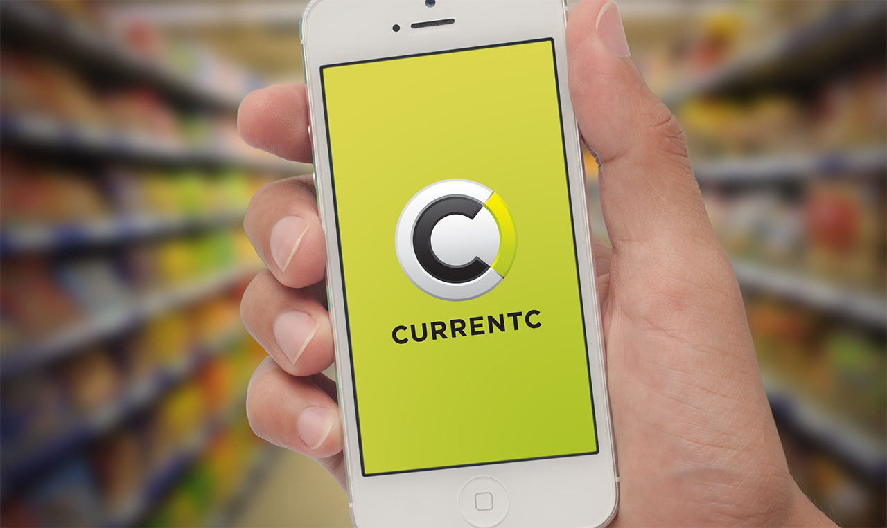 A person is holding up a cell phone with the Currentc logo on it.