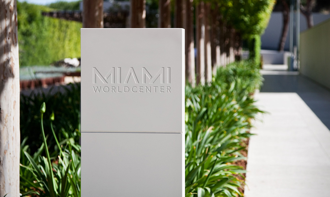 The Miami Worldcenter sign boldly stands in the middle of a grassy area, establishing a sense of place.