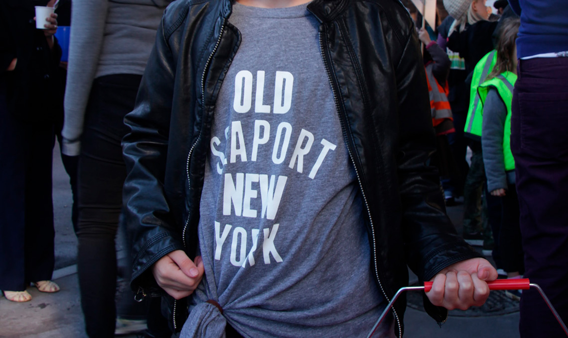 A girl wearing a t-shirt that says Old Seaport New York.