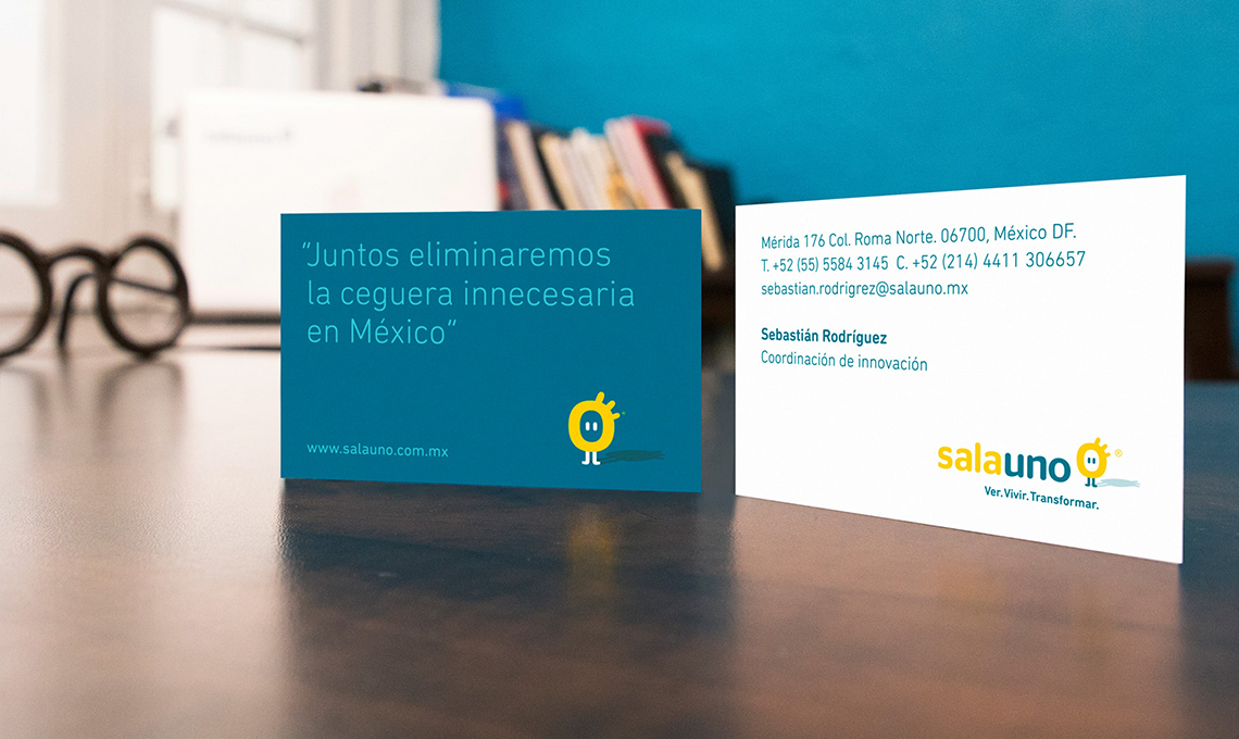 Two striking business cards redefining the experience of seeing, placed neatly on a table next to a stylish desk.