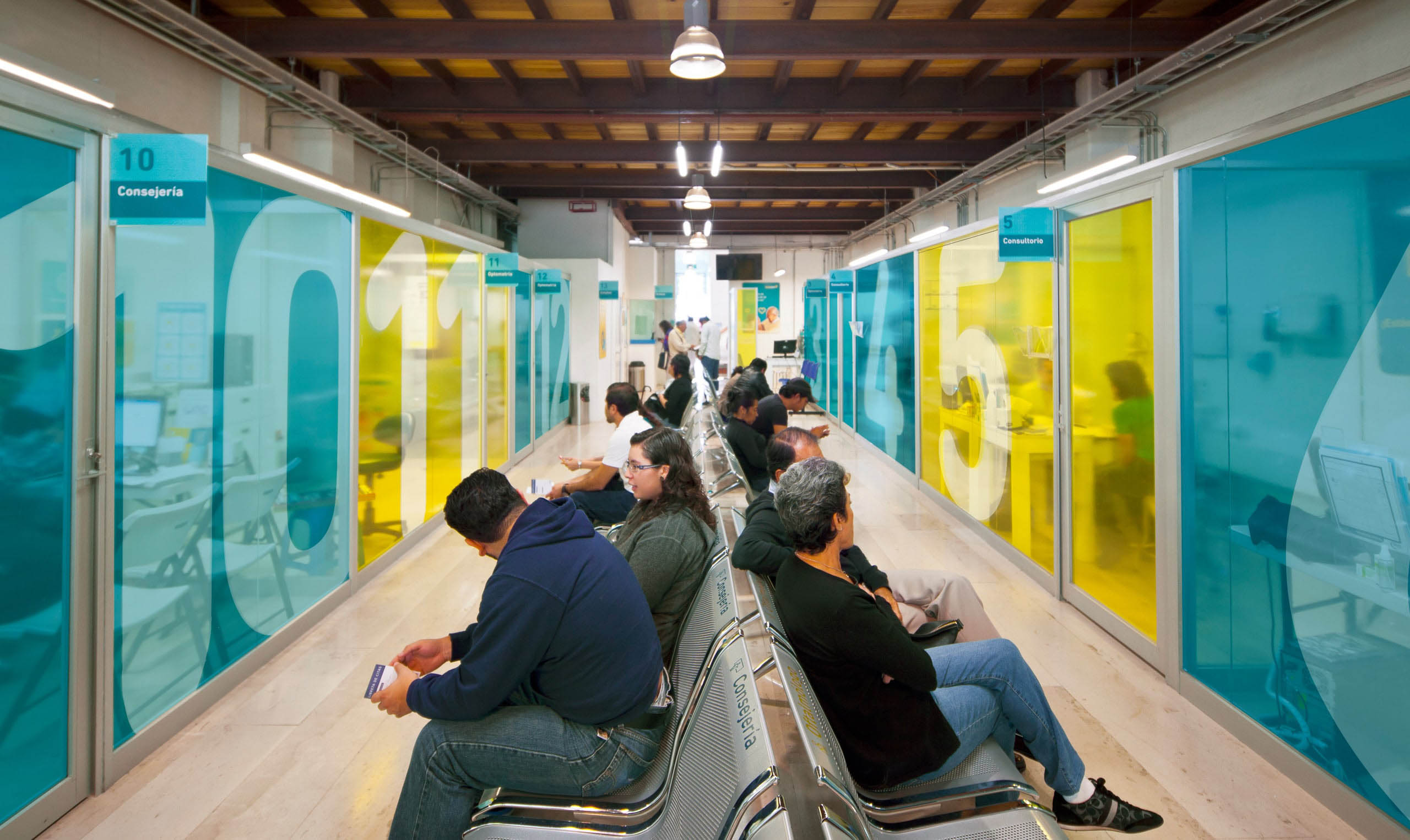 A group of people sitting in a hallway with colorful walls, redefining the experience.
