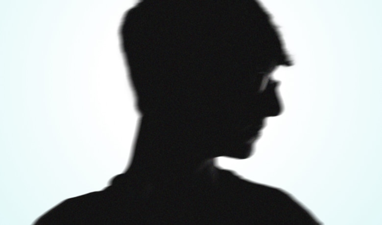A silhouette of a man with glasses.