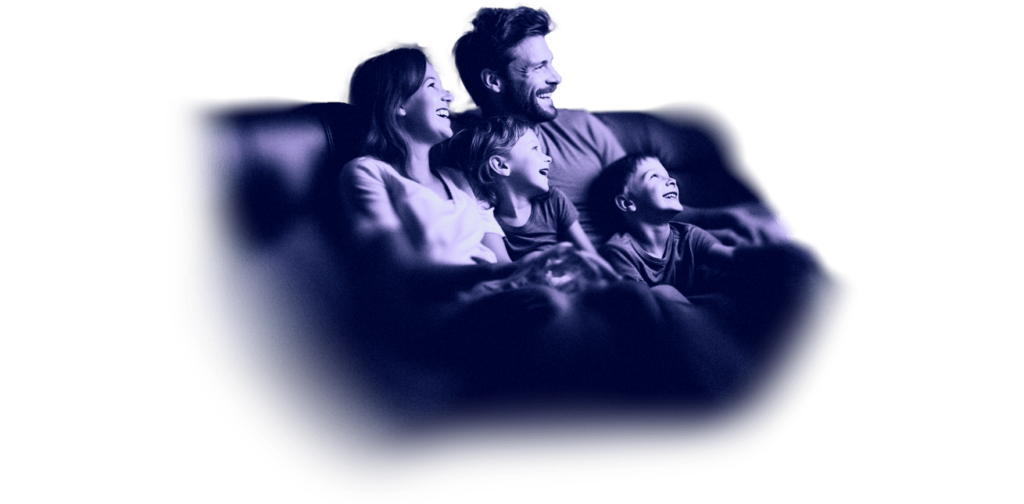 a family sitting on a sofa watching television