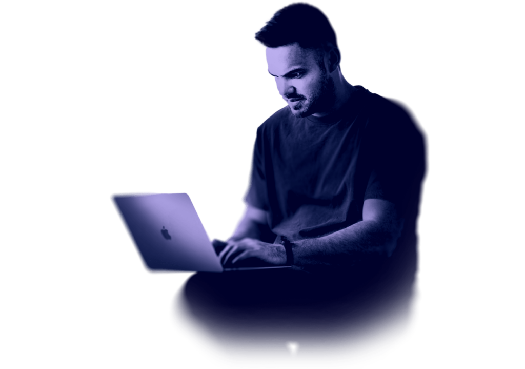 A younf man sitting with a laptop