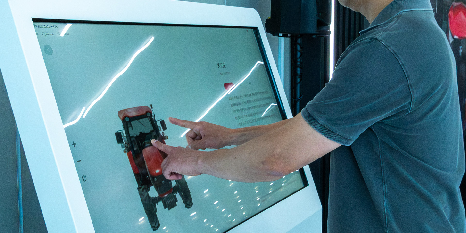 A man interacts with the TYM tractor, using his fingers to see the tractor’s
360 degree view and description via the tool PresentationOS.