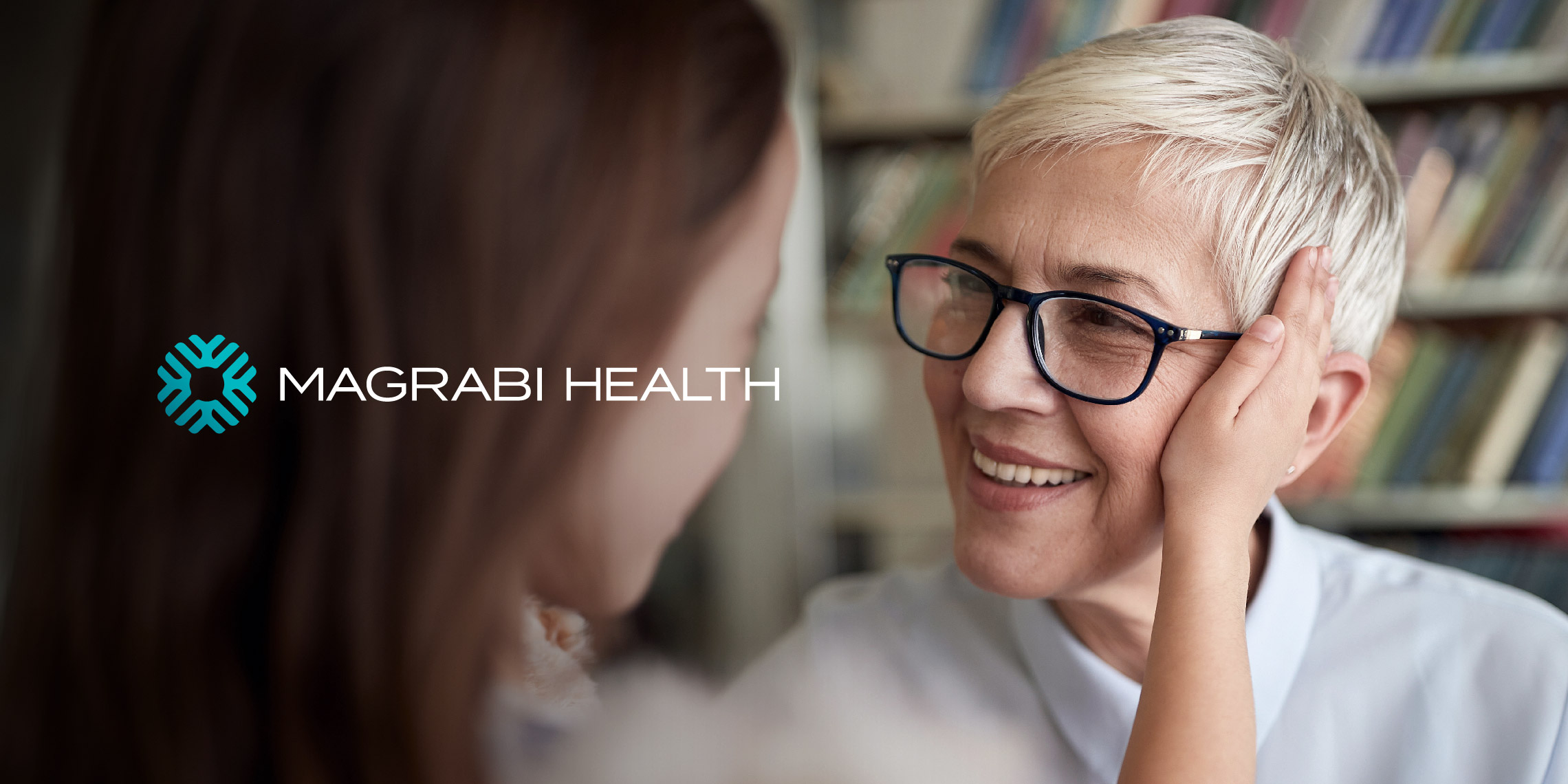 The Magrabi health logo with the watermark symbol, designed by MBLM over a picture of a old lady wearing glasses, honoring the brand’s ophthalmology legacy.