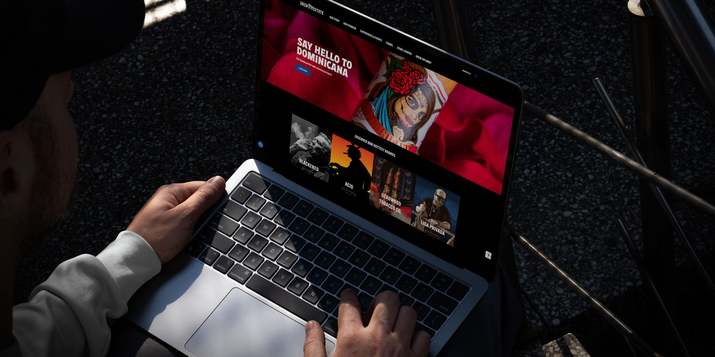 Person using a laptop outdoors, browsing a streaming service with a feature on "Queen of the South" and other TV show thumbnails visible on the screen.