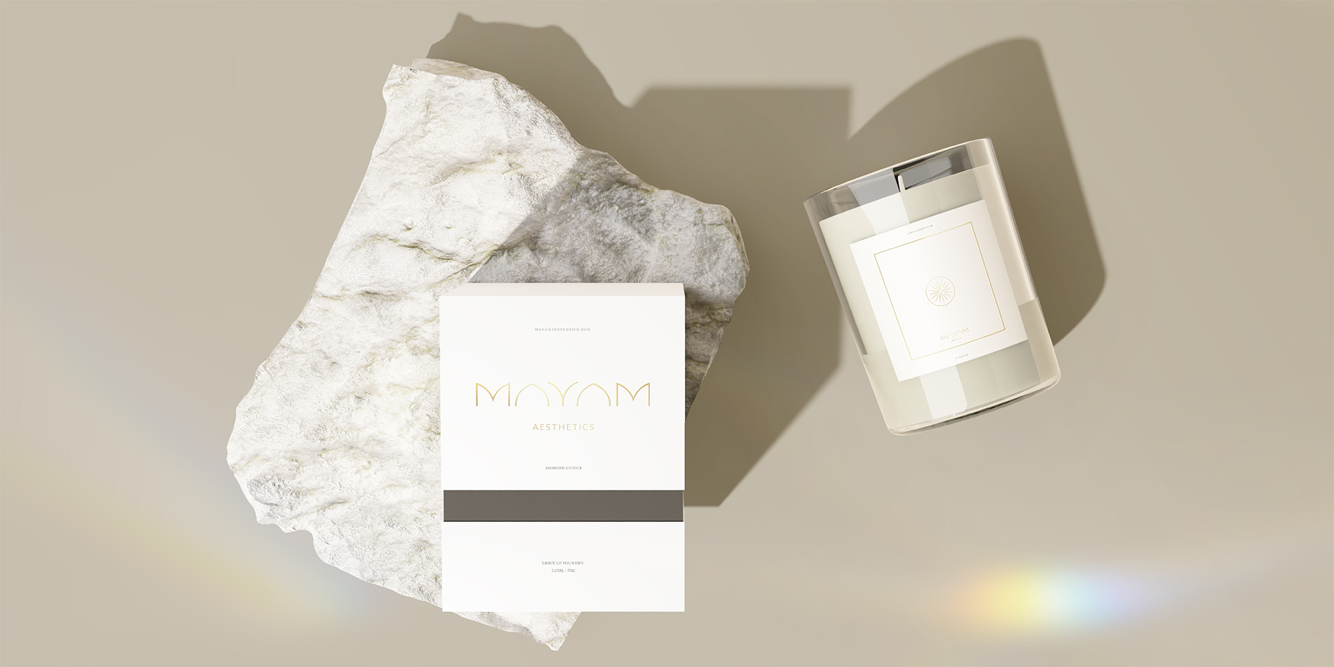Two Mayam branded beauty products shot placed on their back under a strong directional light placed at the bottom left of the image. One is placed against a plain background, while another is placed above a white marble slab.