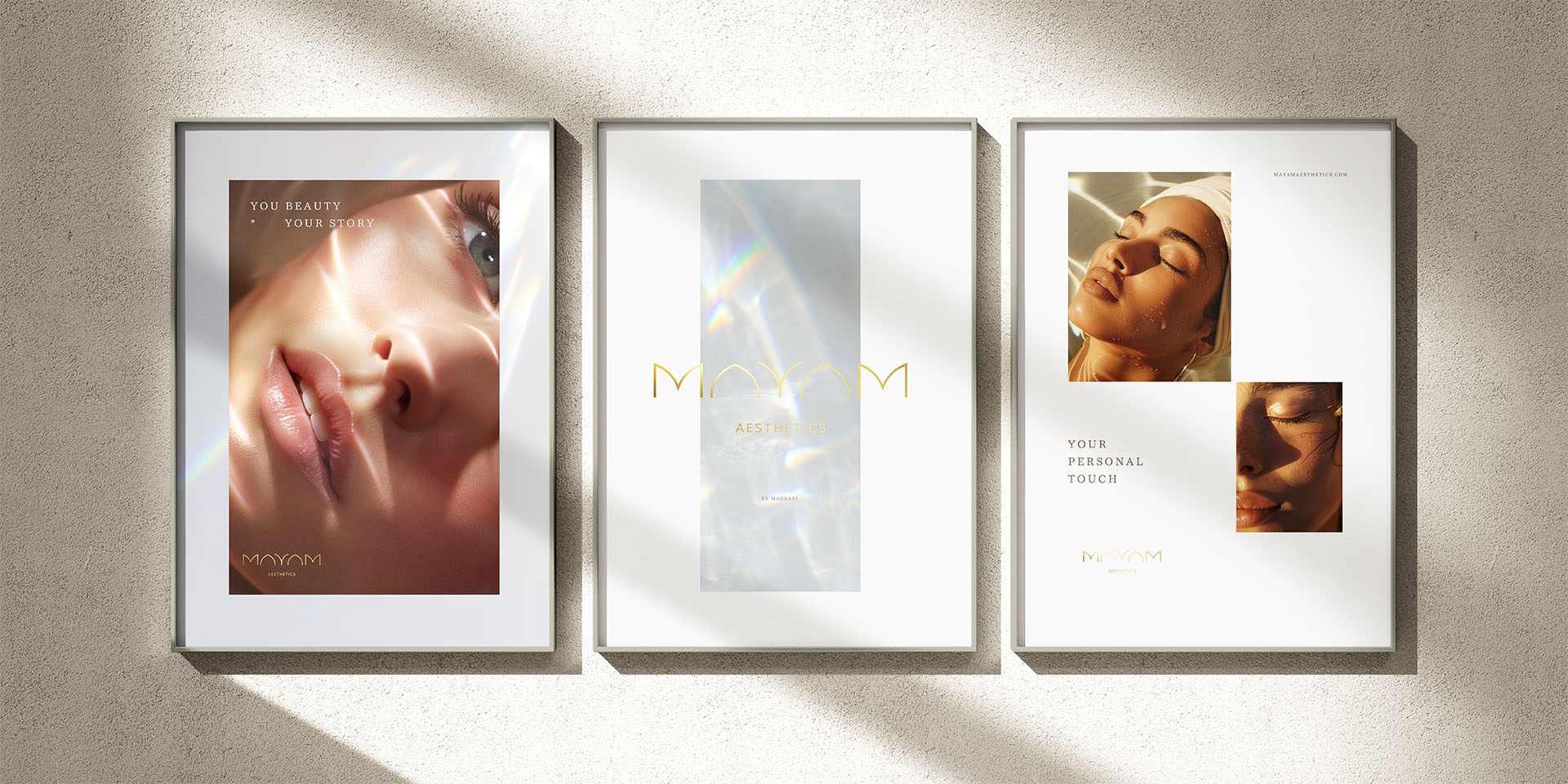 Three brand adverts hanging on a white specked wall, with one poster having one close-up image of a woman with light streaks on their face with “Your Beauty, Your Story” messaging, the second with light with iridescent rays and Mayam branding, and the third has “Your Personal Touch” messaging and two images of woman getting a facial, with light shining on their face.