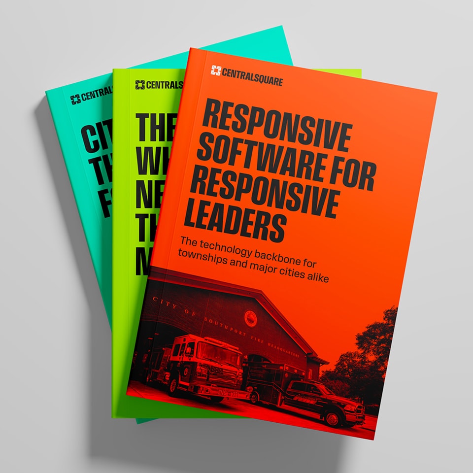Three books with brightly colored covers are stacked, featuring bold titles about city technology and leadership, published by CentralSquare. The top book is orange with an image of fire trucks.