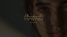 Close-up of a person's face partially in shadow with the gold text "MAYAM AESTHETICS" displayed in the center.