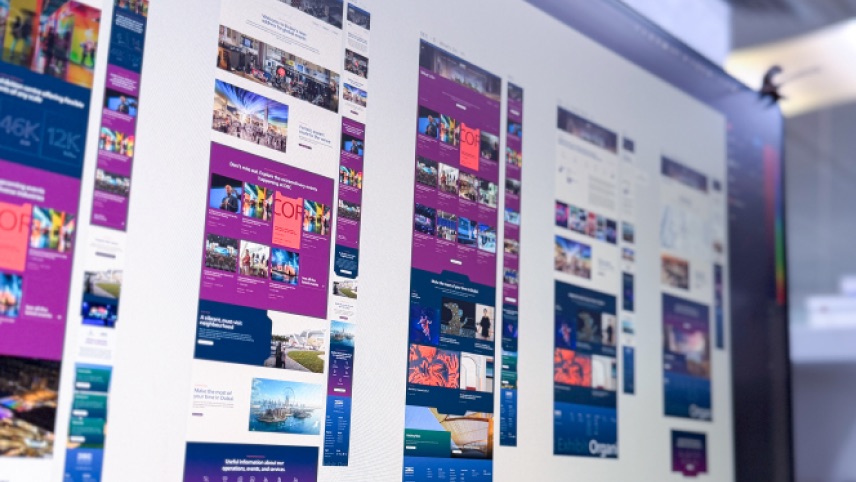 Several colorful website design mockups are displayed on a computer screen, showcasing various layout options and content arrangements.