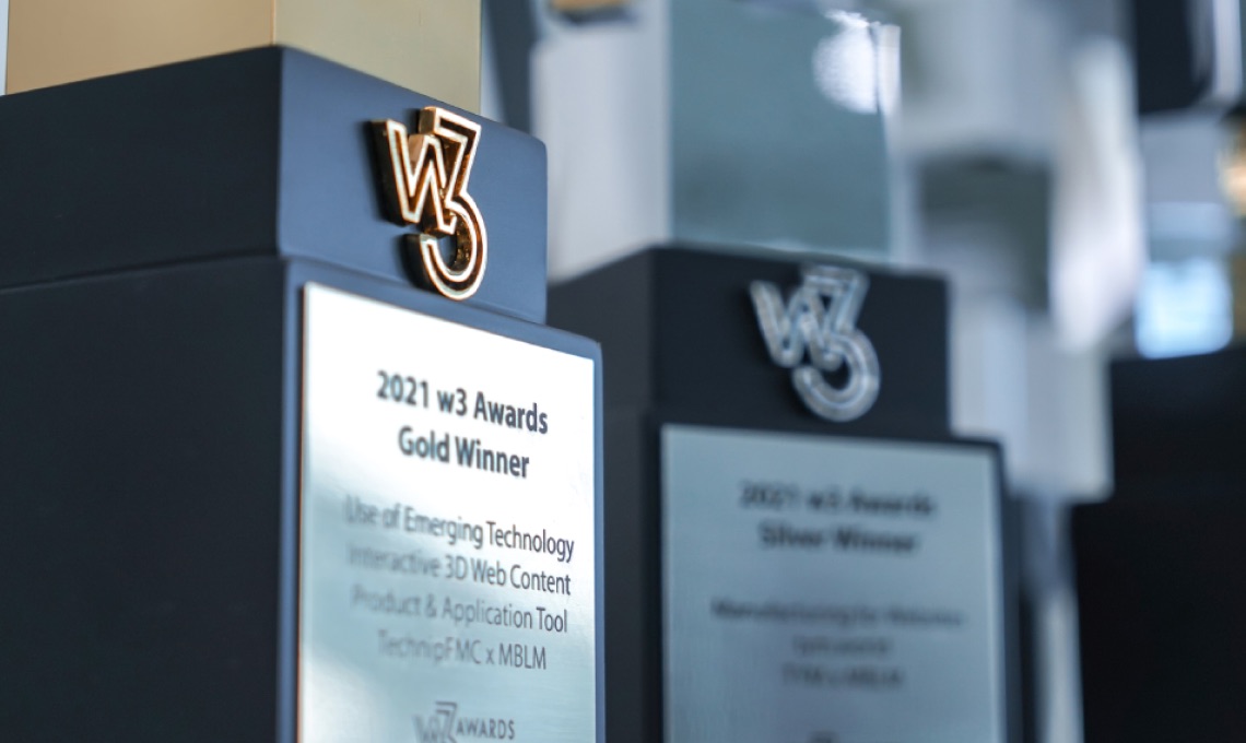 Close-up of two W3 Awards trophies, one labeled “2021 W3 Awards Gold Winner,” with engraved details visible, and the other slightly blurred in the background.