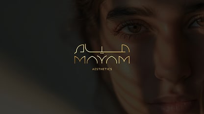 Close-up of a person’s face with soft lighting and shadow, overlaid with the gold logo text “Alya Moyam Aesthetics” in the center.