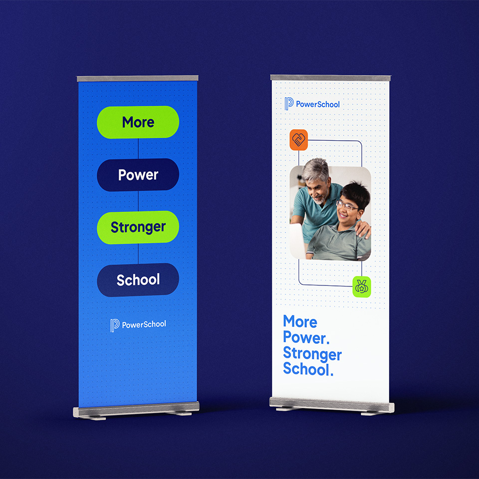 Two PowerSchool pull-up banners reading “More Power. Stronger School.” One is blue and lime; one shows a man and boy smiling.