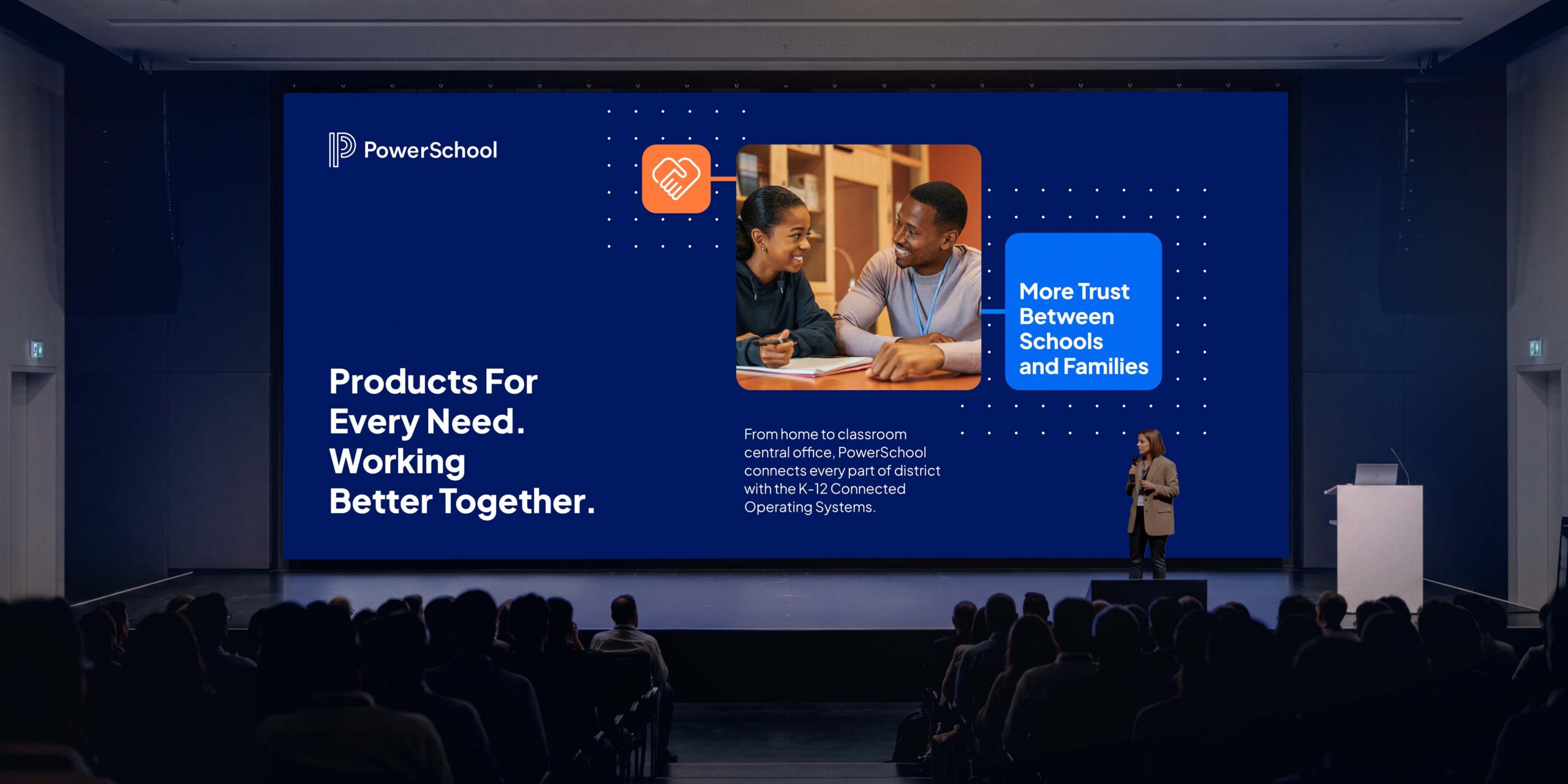 A speaker presents a PowerSchool slide reading “Products For Every Need. Working Better Together.” to a large audience.